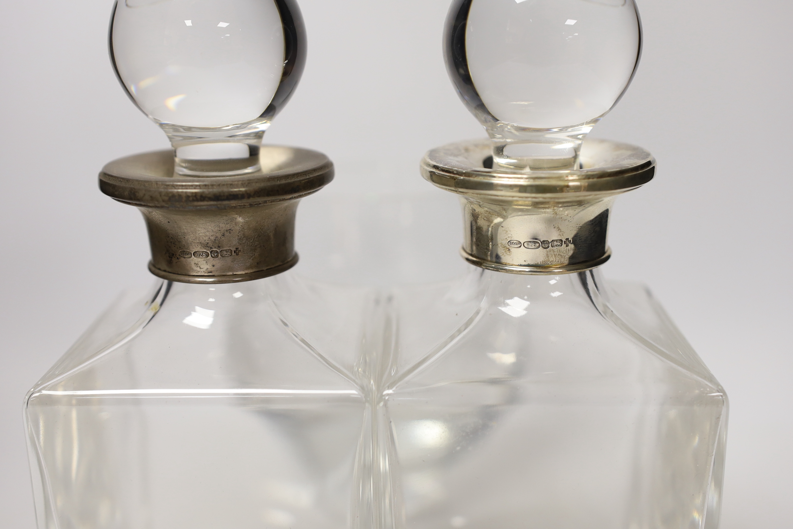 A pair of silver collared decanters and stoppers and two glass vases, decanters 26cm